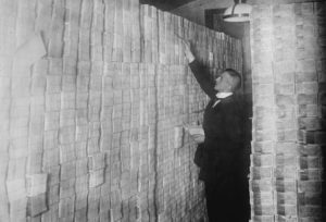 GERMANY - CIRCA 1900: Inflation in Weimar Germany has paper money stacked from Floor to Ceiling in a Berlin Bank; banker is counting sheaves of bundled notes. (Photo by Buyenlarge/Getty Images)